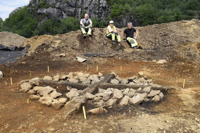 Bilde av arkeologer foran en grom som er renset fram